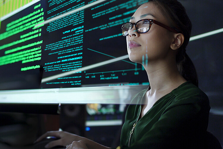 woman facing computer screen with reflection