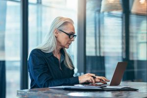 data analyst works on laptop in an office