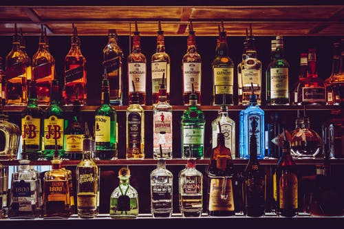 Bottles of alcoholic beverages lined up neatly on shelves.