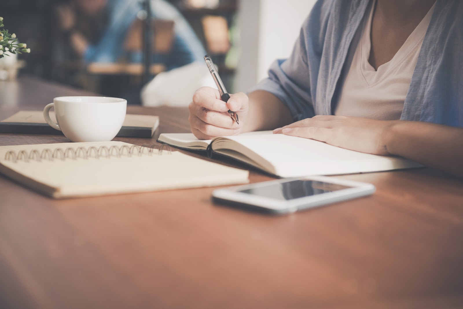 a college student works on balancing her budget in a notebook