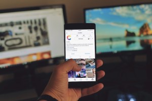 A close-up of a person scrolling through an Instagram account on a smartphone.