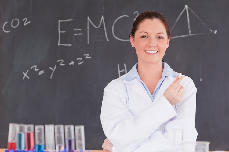 Physicist draws an equation on a chalkboard.