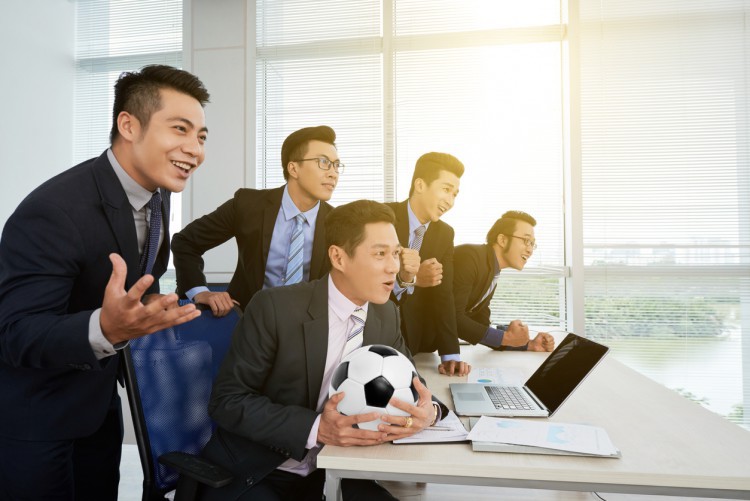 Businessmen watch soccer match.