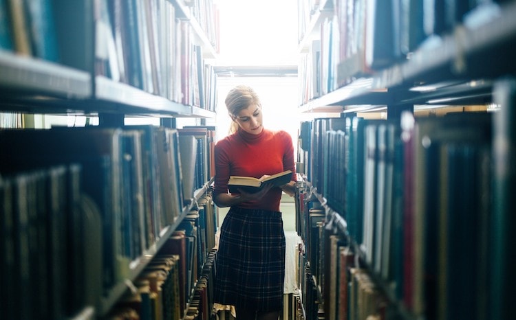 A librarian opens up a book to read.