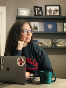 Lexy Vreeland in front of a computer with a cup of coffee