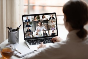 A manager chats with her remote sales team on a laptop.