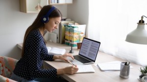 An online master’s student studies on a laptop.