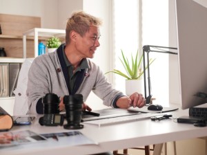 A smiling graphic designer works on a project.