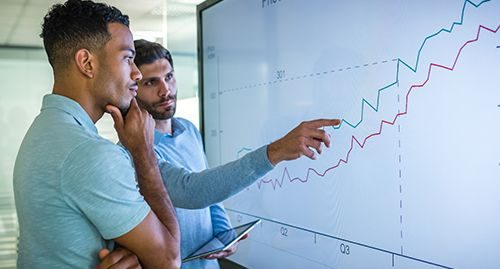 undergraduate students analysing a line graph on a screen