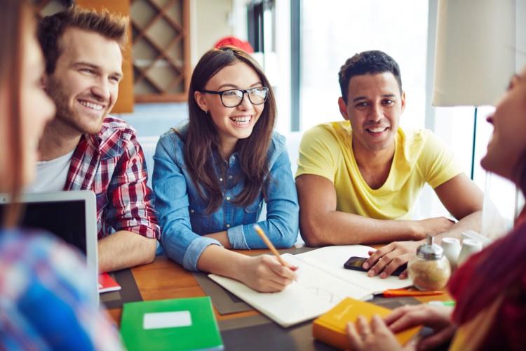 Smiling college students study at a table