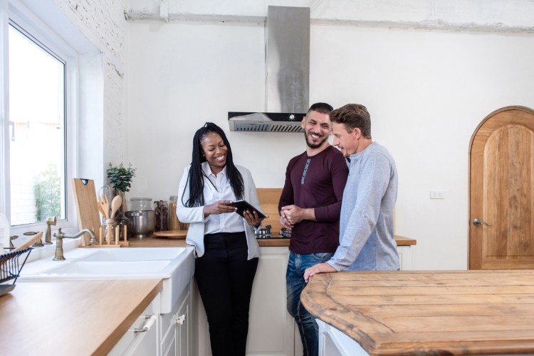 A property manager shows a couple the kitchen of a home.