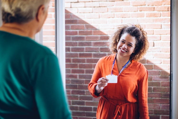 A social worker pays a visit to an elderly woman.