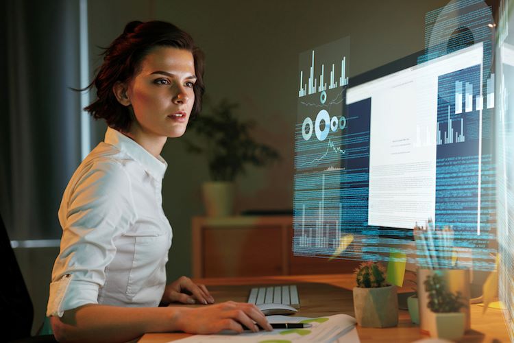 Female data scientist analyzing a computer screen with data visualizations.