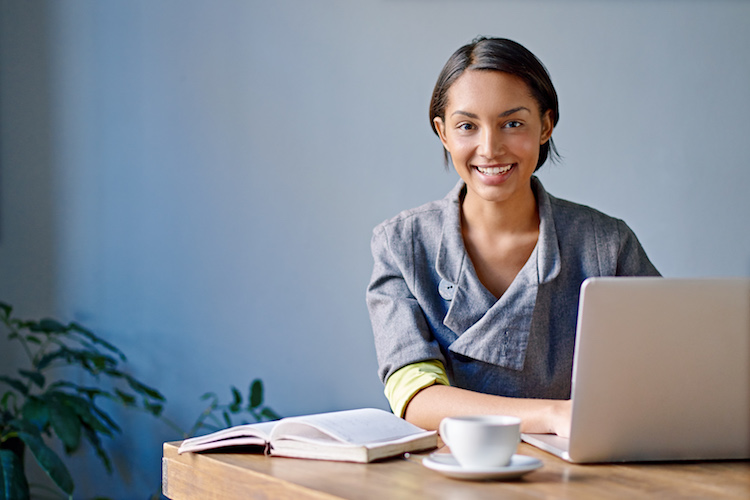 Portrait of a young woman working on a laptop in an office