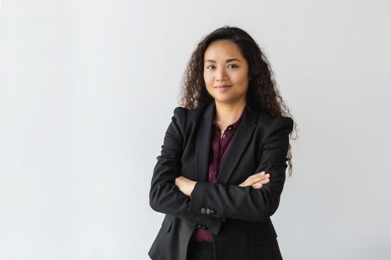 Female professional standing with her arms crossed.