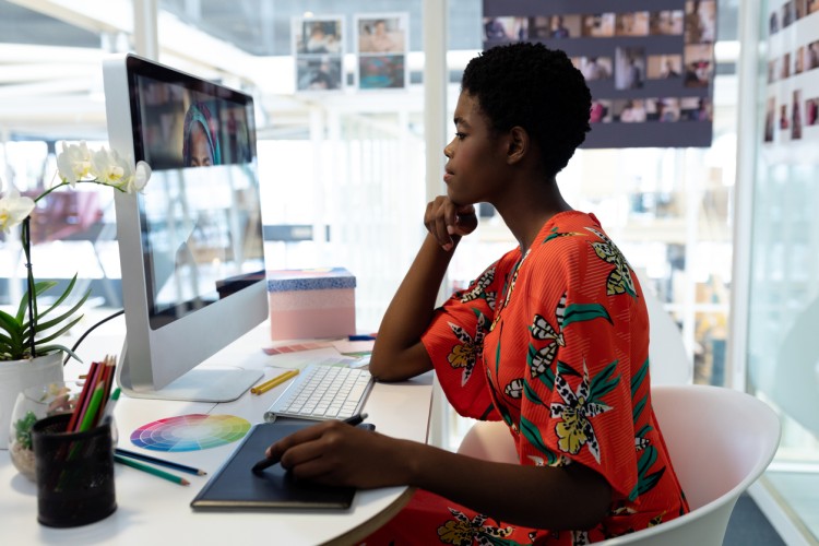 A motion graphics designer works at a large monitor