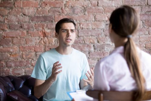 A social service specialist consults with drug addicted patient.