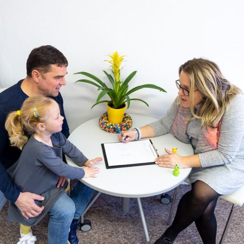 A sociologist conducts an assessment with child during counseling session.