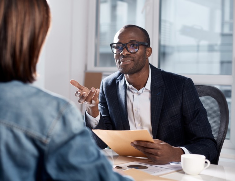 A sports manager discusses a contract with a vendor in their office.