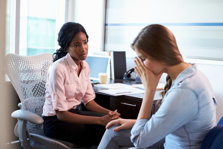 A counselor sits with a patient.