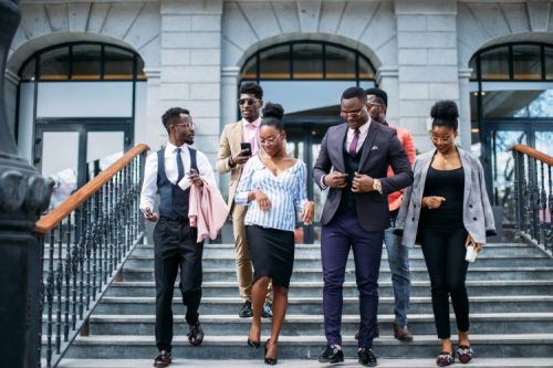 A group of Black professionals walking out of an office building.