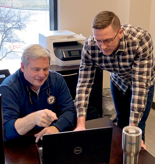 Two men looking at a laptop