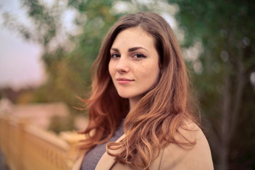 Woman standing outdoors and looking into the camera.