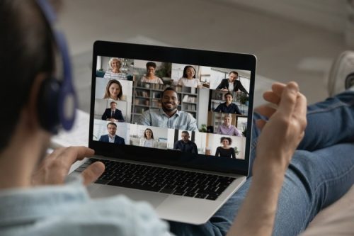 Worker uses laptop to attend meeting remotely.